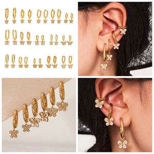 Détail de boucles d'oreilles créoles papillon dorées 18k avec cristaux de zircon