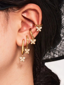 Détail macro de boucles d'oreilles papillon avec zircons et placage en or 18 carats