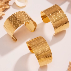 Bracelet manchette large 35mm en acier plaqué or avec motifs floraux et texturés
