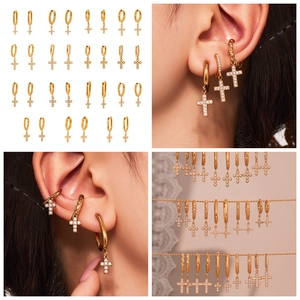Détail de créoles plaquées or 18k avec pendentifs croix en zircon 5A et designs texturés
