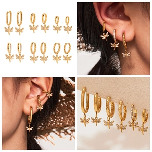 Detailed view of gold dragonfly charm earrings set with sparkling cubic zirconia stones