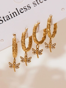 Detail of four golden dragonfly drop earrings with micro-inlaid zircons and diverse textures