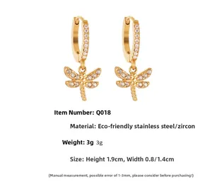 Detail of gold dragonfly earrings with micro-inlaid zircons and stainless steel texture