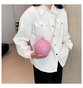 Close-up of pink round sequin bag with gold ring handle and metal chain detail