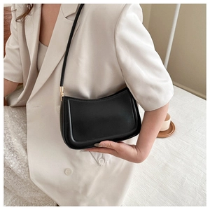 Detail of minimalist black hobo bag with smooth finish and elegant gold hardware