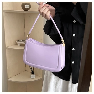 Detail of lavender baguette bag with smooth leather finish and gold metal hardware