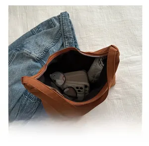 Top view of spacious brown tote interior holding a phone, wallet, and folding umbrella