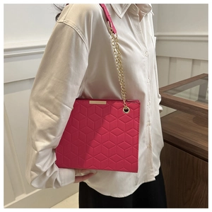 Detail of rose red tote bag with 3D geometric embossing and gold chain strap