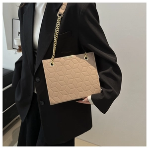 Detail of beige shoulder bag with geometric embossed texture and gold chain strap