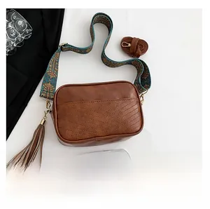 Brown retro camera bag with ethnic embroidered wide strap and fringe detail showing scale