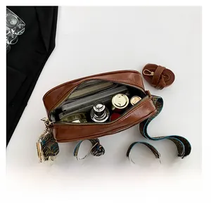 Spacious interior of retro brown crossbody bag with ethnic strap and daily essentials