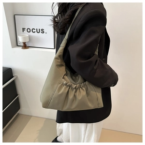 Detail of soft pleated olive green nylon shoulder bag showing ruched texture on the side