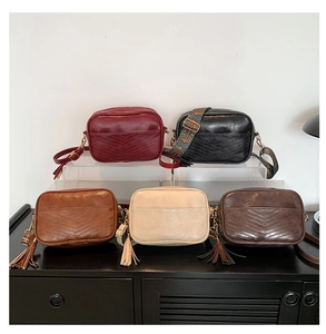 Collection of retro crossbody bags in five colors with tassels and metal hardware