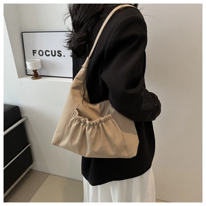 Detail of light beige pleated tote bag with drawstring pocket and soft leather texture