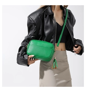 Litchi pattern green crossbody bag with fringe tassel shown on a stylish model