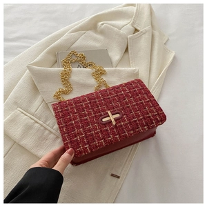 Détail du sac bandoulière en tweed rouge foncé avec chaîne dorée et fermoir rotatif