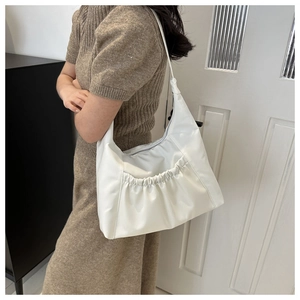 Detail of soft white pleated PU leather shoulder bag with smooth zipper closure for women