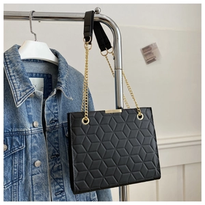 Detail of black geometric embossed shoulder bag with gold chain and metal top bar
