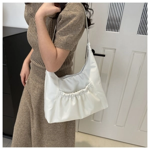 Close-up of white soft PU hobo bag featuring stylish pleated pockets and minimalist design