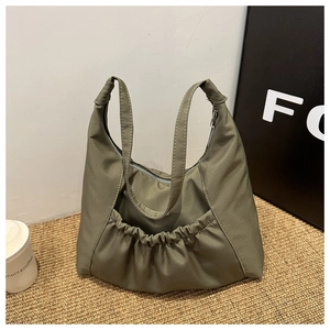Close-up of olive green nylon bucket bag with ruched pockets and zipper closure