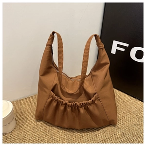 Close-up of brown soft PU hobo bag featuring decorative ruched front pocket detail