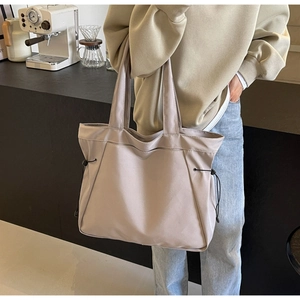 Detail of light coffee tote bag featuring adjustable side drawstrings and durable fabric