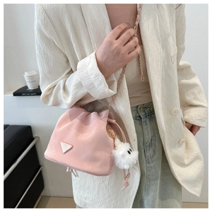 Detailaufnahme der rosa Kordelzug-Beuteltasche mit Goldkette und weichem Plüsch-Anhänger
