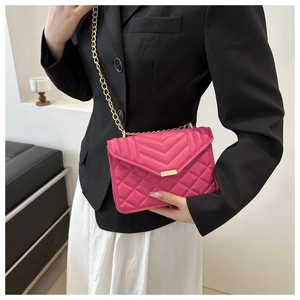 Detailed view of pink quilted leather shoulder bag with gold chain strap and metal clasp