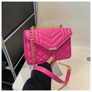 Détail du sac bandoulière fuchsia matelassé avec surpiqûres en V et chaîne dorée