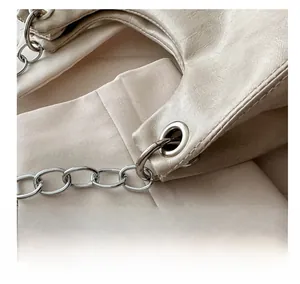 Dettaglio borsa in pelle PU crema con catena in argento e occhielli in metallo