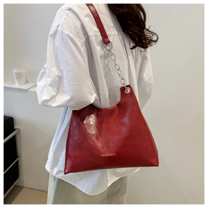 Detail of vintage red shoulder bag with silver chain strap and fashion lettering