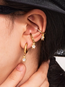Macro shot of 18k gold bear earring set featuring sparkling 5A zircon inlay on model