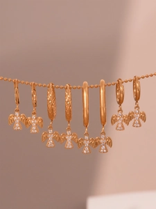 Detailansicht goldener Engelsflügel-Ohrringe mit glitzernden Zirkonia-Steinen