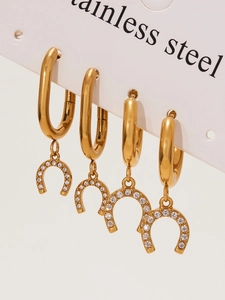 Macro detail of horseshoe drop earrings with sparkling crystals on a 18k gold plated base