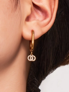 Detail van dubbele ring oorbellen met micro-gezette zirkoon op model met goud