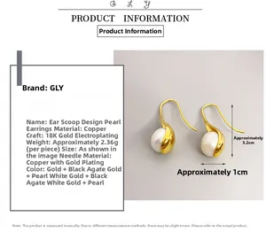 Macro detail of 18K gold plated brass earrings featuring white pearl and black agate