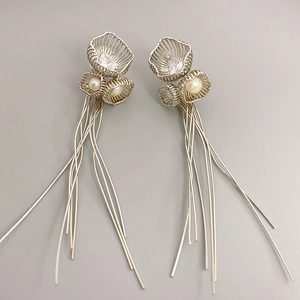 Boucles d'oreilles fleurs argentées à pompons avec perles et strass sur fond gris