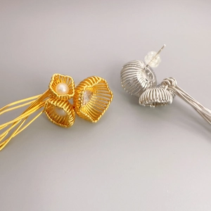 Vue détaillée de boucles d'oreilles sphères évidées avec perles en or et argent