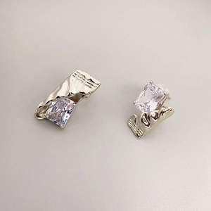 Minimalist silver stud earrings featuring oversized rectangular crystals and wavy metal edges