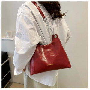 Dettaglio della borsa hobo in ecopelle rossa con catena argento e testo moda