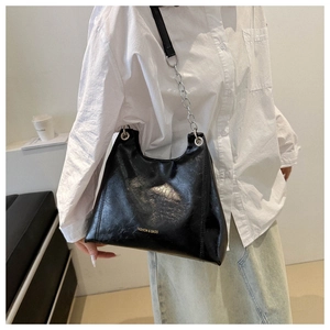 Détail du sac bandoulière en cuir ciré noir avec texte doré et bandoulière chaîne