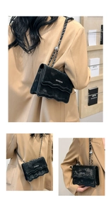 Detail of black velvet crossbody bag featuring wavy flap and silver bead chain strap