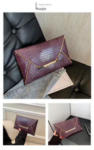 Close-up of purple crocodile pattern envelope clutch with gold metal trim and flap