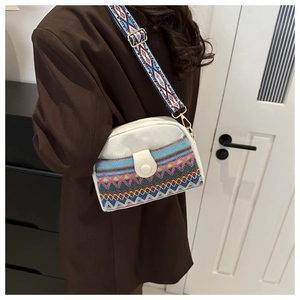 Détail du sac coquille en toile avec motifs ethniques colorés et large bandoulière