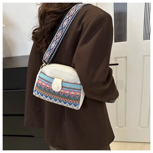 Détail d'un sac bandoulière en toile bohème avec broderie ethnique et sangle tissée