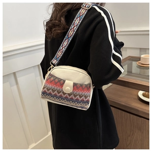 Détail d'un sac en toile ethnique avec motifs de vagues rouges et large bandoulière