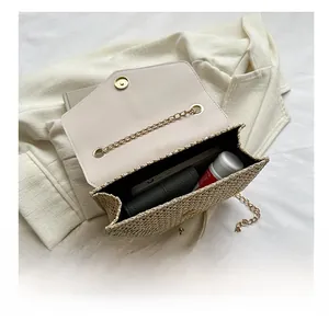 Top view of woven straw crossbody bag interior showing daily essentials and golden chain