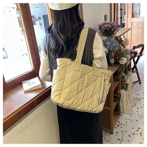 Quilted nylon tote bag in cream beige with large diamond pattern and wide shoulder strap