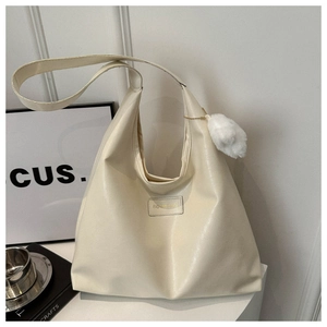 Detail of off-white oversized tote bag with plush pompom and fashion brand logo plate