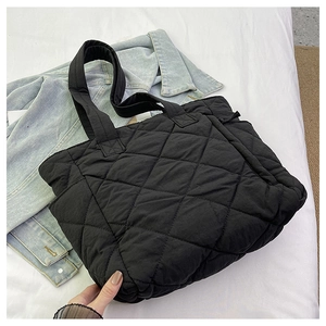 Close-up of black quilted nylon fabric and diamond stitching on large tote bag